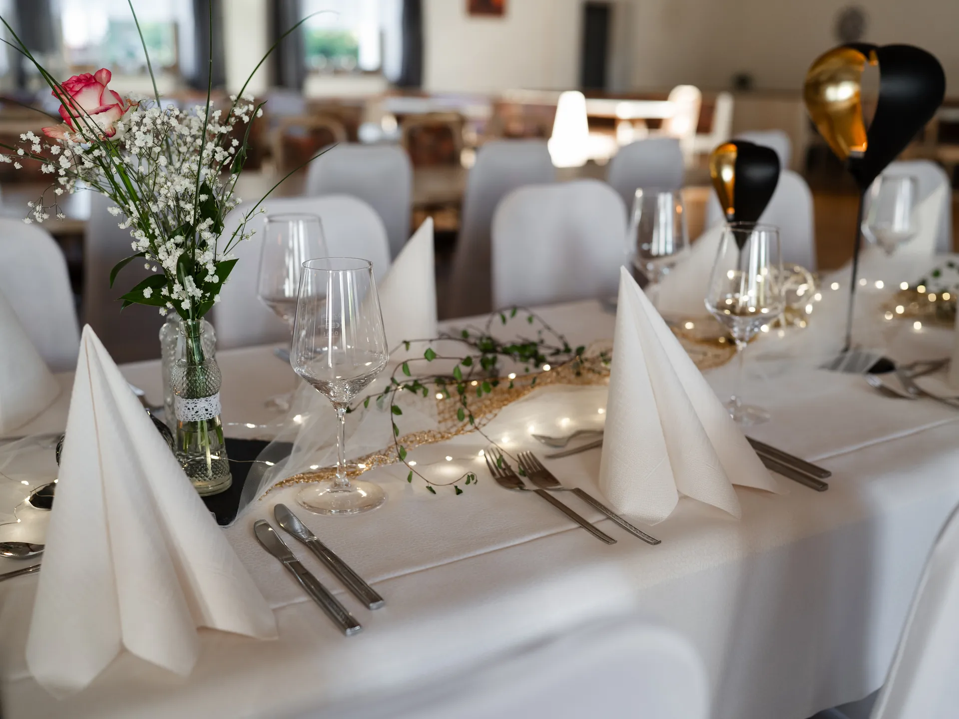 Festlich gedeckte Hochzeitstafel mit Kerzen und Blumenschmuck im Gasthaus Schwarz